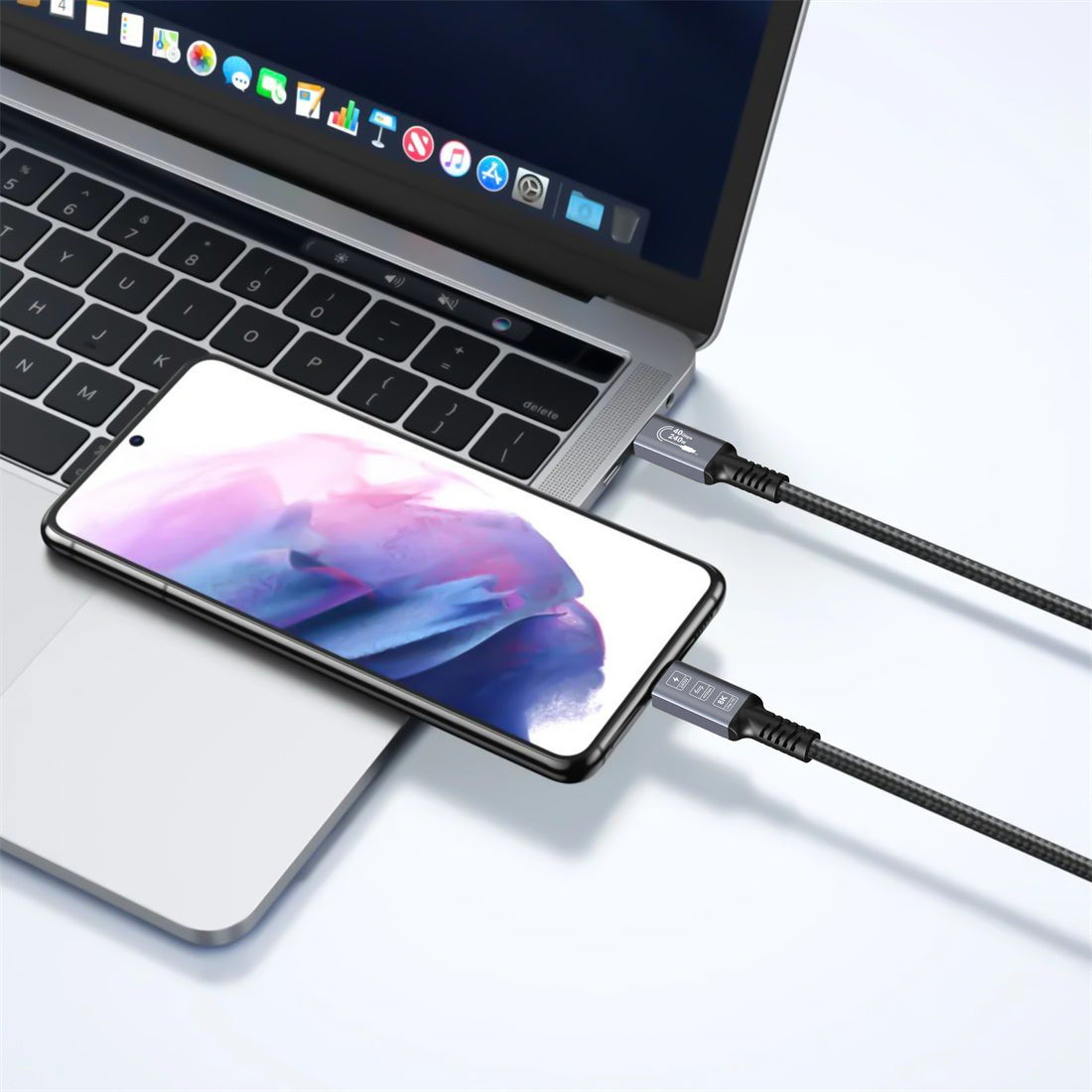 Smartphone connected to a laptop via a cable on a white background